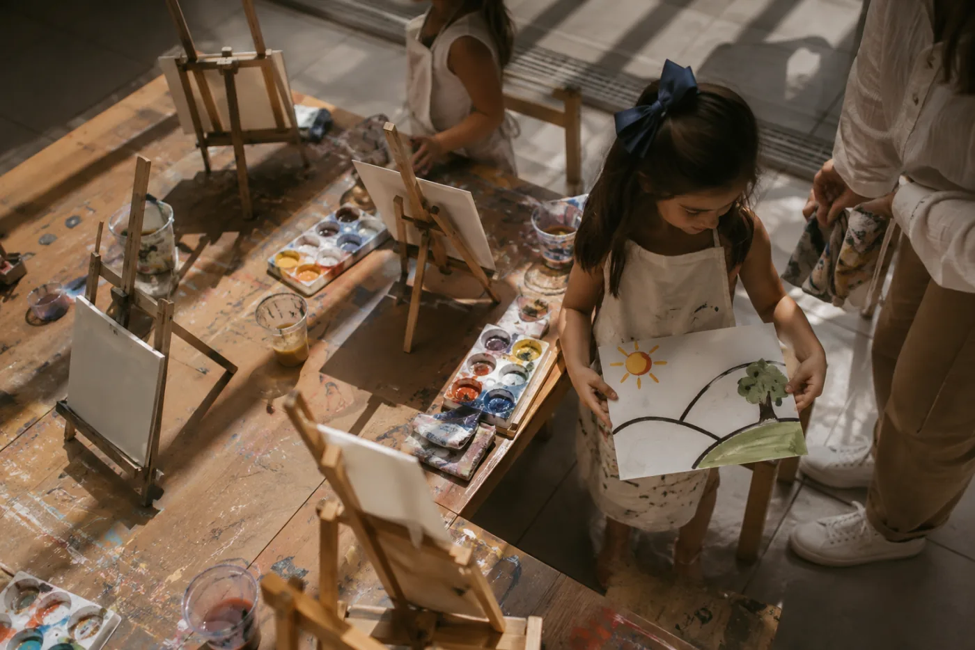 Niña llevando a casa un paisaje pintado por ella